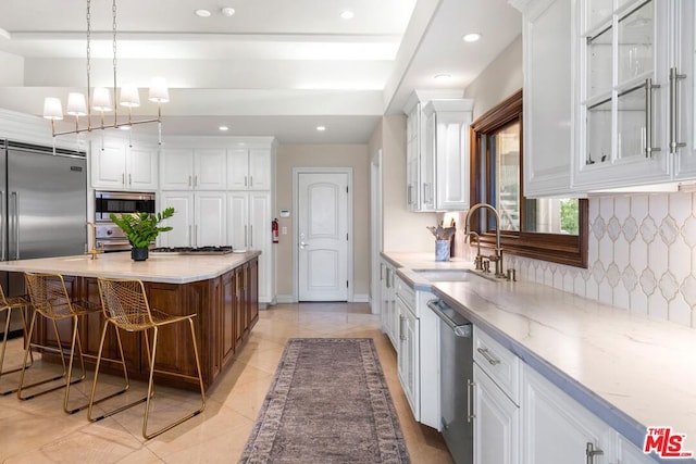 kitchen with backsplash, white cabinets, sink, built in appliances, and light tile patterned floors