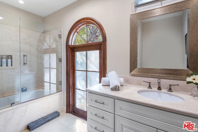 bathroom featuring vanity, tile patterned floors, and enclosed tub / shower combo