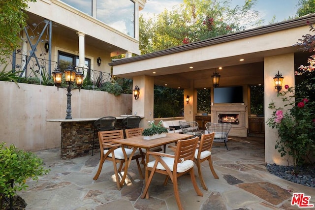 view of patio featuring an outdoor living space with a fireplace