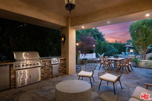 patio terrace at dusk featuring area for grilling