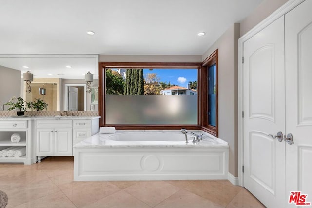 bathroom with tile patterned flooring, vanity, and shower with separate bathtub