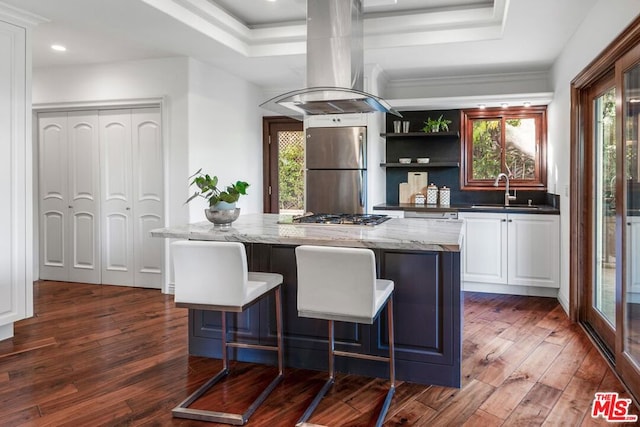 bar with stainless steel appliances, dark hardwood / wood-style flooring, dark stone counters, island range hood, and white cabinets