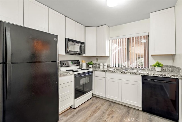 kitchen with light stone counters, sink, black appliances, light hardwood / wood-style flooring, and white cabinetry