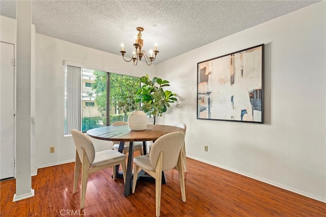 dining area with a chandelier, a textured ceiling, and hardwood / wood-style flooring