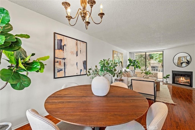 dining space with an inviting chandelier, a textured ceiling, and hardwood / wood-style flooring