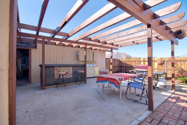 view of patio featuring a pergola, a mountain view, and an outdoor kitchen