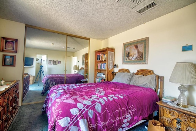 bedroom with a textured ceiling, carpet floors, and a closet