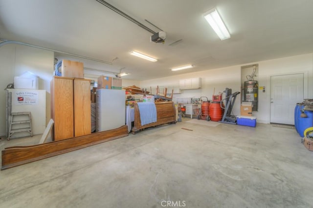 garage featuring strapped water heater and a garage door opener