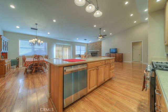 kitchen featuring ceiling fan with notable chandelier, stainless steel appliances, light hardwood / wood-style flooring, a center island, and hanging light fixtures