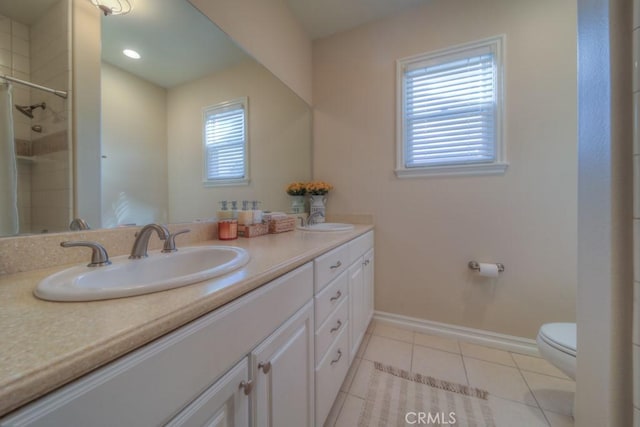 bathroom featuring tile patterned flooring, vanity, toilet, and tiled shower