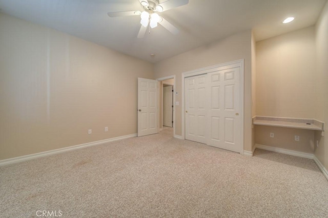 unfurnished bedroom featuring ceiling fan, light carpet, and a closet