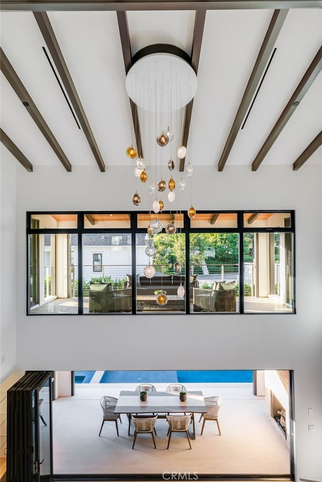 interior space with beam ceiling and an inviting chandelier