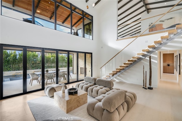 living room featuring beam ceiling, french doors, and high vaulted ceiling