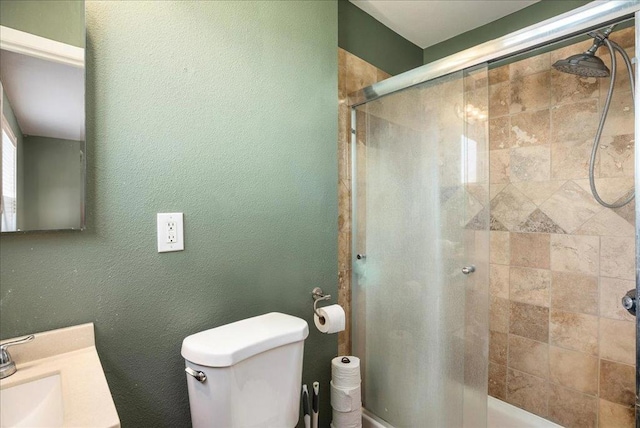 bathroom featuring walk in shower, vanity, and toilet