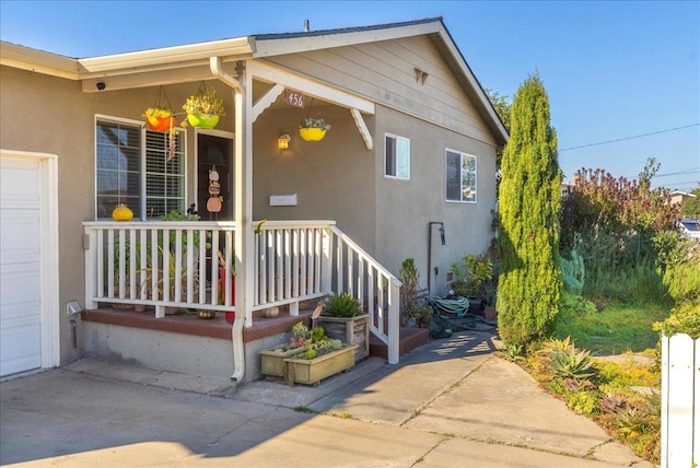 entrance to property featuring covered porch and a garage