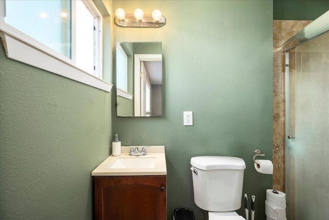 bathroom with toilet, walk in shower, and vanity