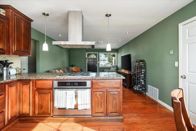 kitchen featuring hardwood / wood-style flooring, kitchen peninsula, island exhaust hood, appliances with stainless steel finishes, and pendant lighting