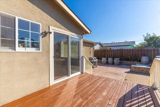 wooden terrace featuring area for grilling and a patio