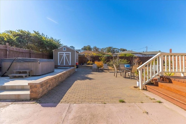 view of patio with a storage shed and a hot tub