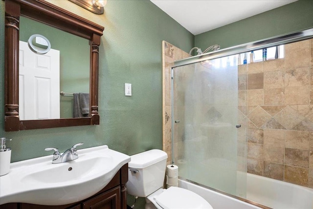 full bathroom featuring combined bath / shower with glass door, vanity, and toilet