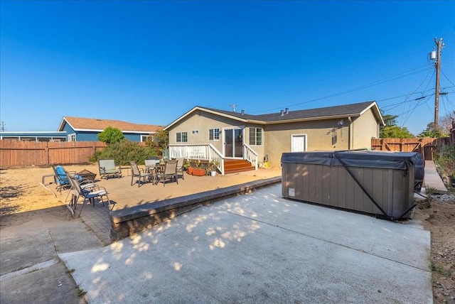 rear view of house with a patio area and a hot tub