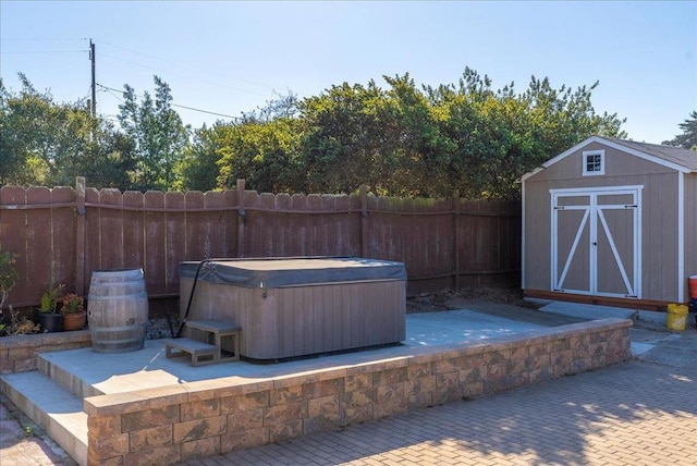 view of patio / terrace featuring a shed and a hot tub