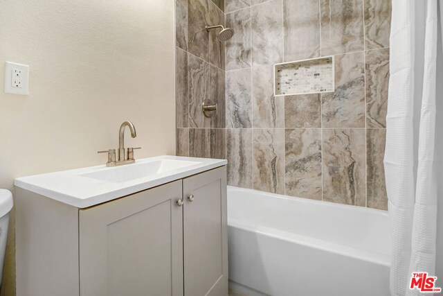 bathroom featuring shower / bath combo with shower curtain and vanity