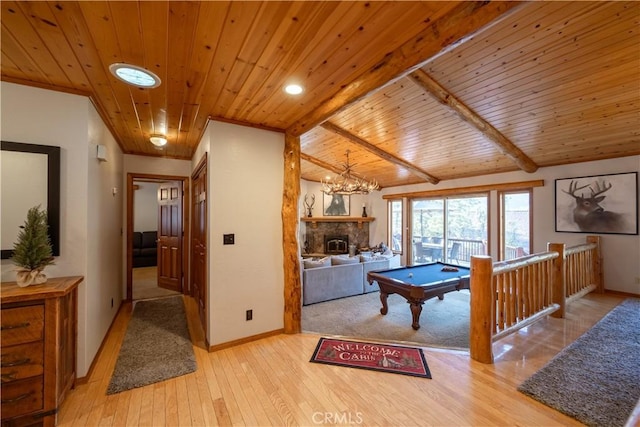 playroom with wooden ceiling, lofted ceiling with beams, a stone fireplace, light wood-type flooring, and pool table