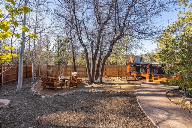 view of yard featuring a wooden deck and a fire pit