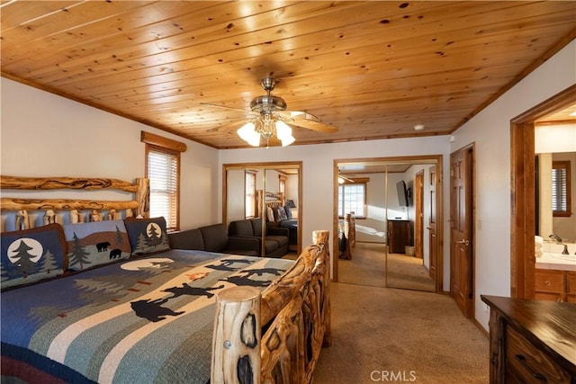 bedroom featuring ceiling fan, wood ceiling, two closets, and light carpet