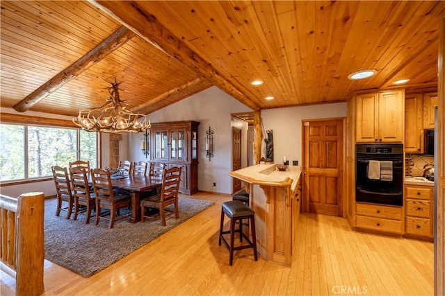 dining space with vaulted ceiling with beams, an inviting chandelier, wood ceiling, and light wood-type flooring