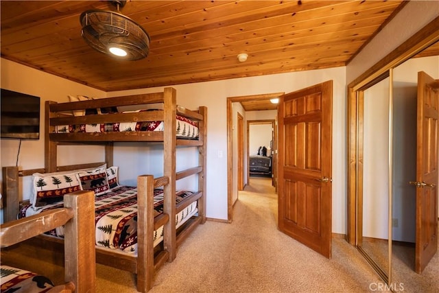 carpeted bedroom with a closet and wood ceiling