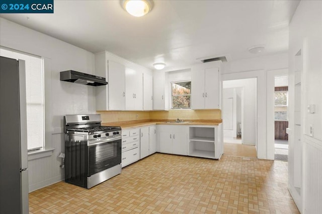 kitchen with white cabinetry, plenty of natural light, stainless steel appliances, and range hood