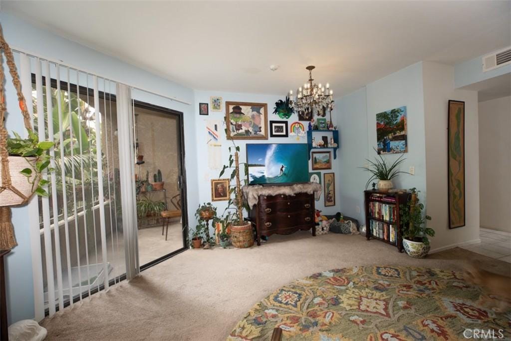 carpeted living room featuring a notable chandelier