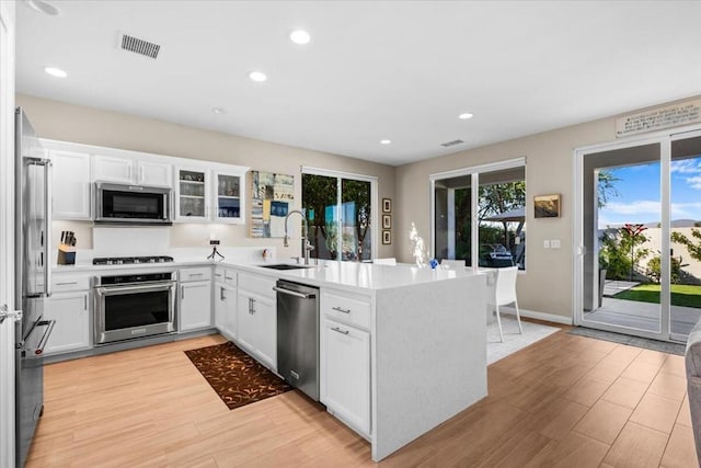 kitchen featuring white cabinets, light hardwood / wood-style floors, sink, and appliances with stainless steel finishes