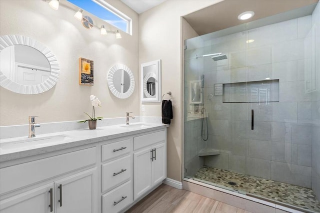 bathroom with hardwood / wood-style floors, vanity, and walk in shower