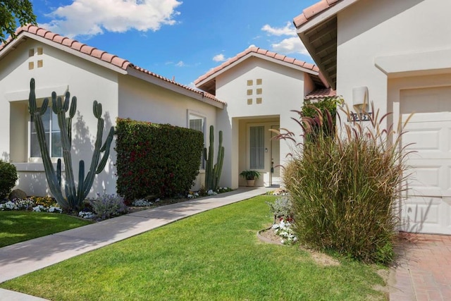 mediterranean / spanish-style home featuring a front lawn and a garage