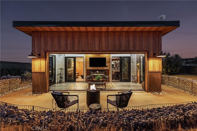 back house at dusk with a patio and a fire pit