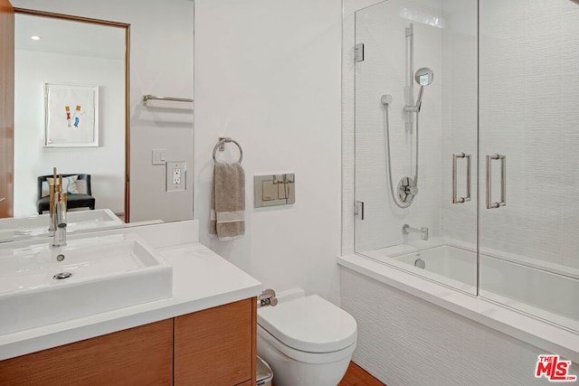 full bathroom with vanity, bath / shower combo with glass door, and toilet