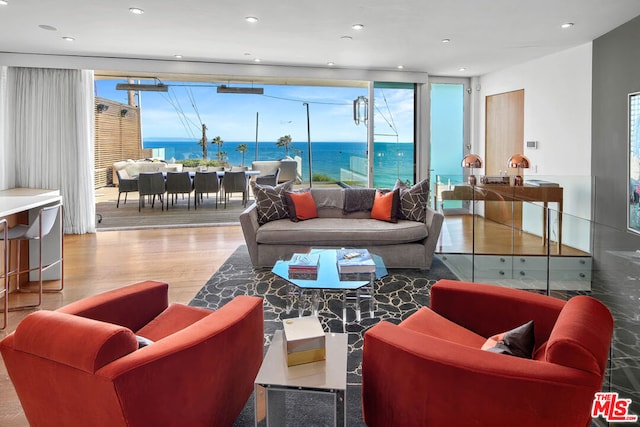 living room featuring a wealth of natural light, a water view, and wood-type flooring