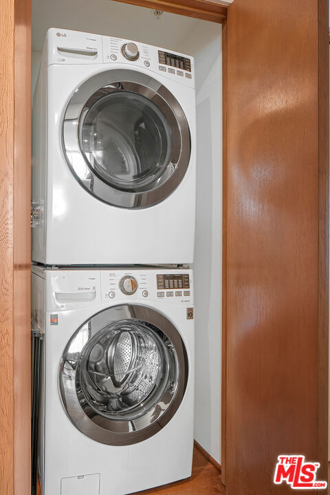 clothes washing area featuring stacked washing maching and dryer