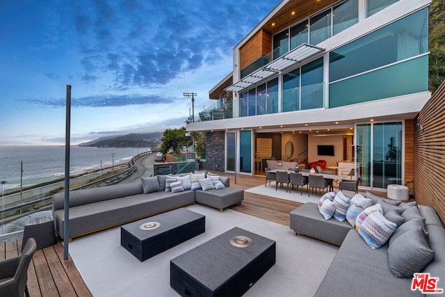 wooden terrace featuring an outdoor living space and a water view