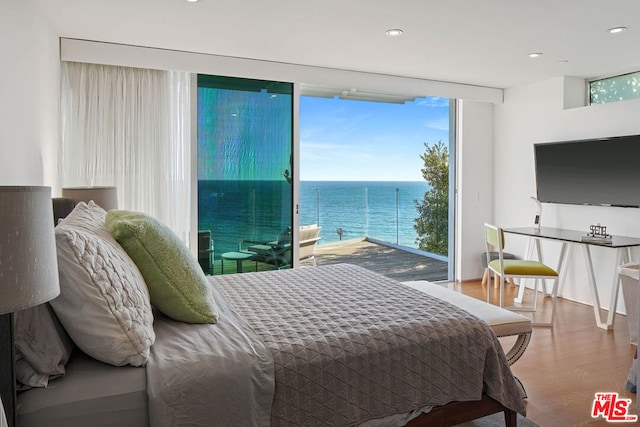 bedroom with hardwood / wood-style floors and expansive windows