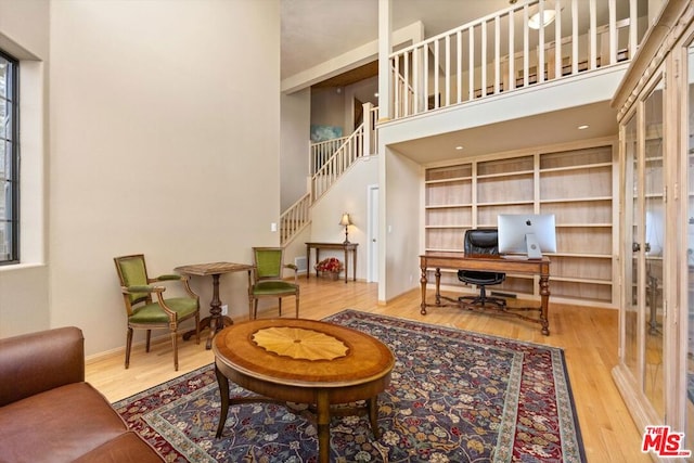 office featuring french doors, hardwood / wood-style flooring, and a high ceiling