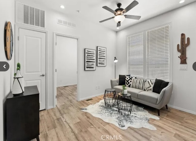 living area with light wood-type flooring, visible vents, baseboards, and recessed lighting