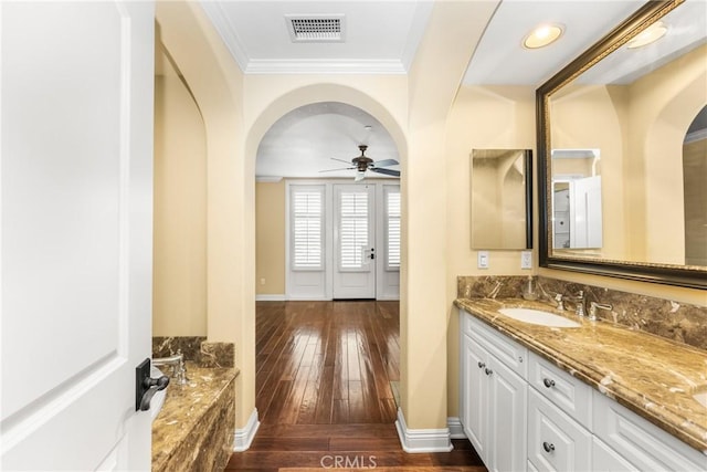 bathroom featuring hardwood / wood-style floors, vanity, ceiling fan, and ornamental molding