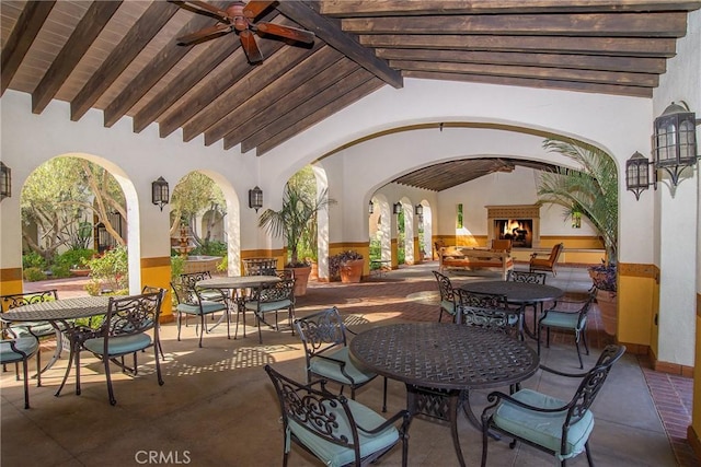 view of patio / terrace with ceiling fan and an outdoor fireplace