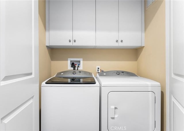 laundry area with cabinets and washing machine and dryer