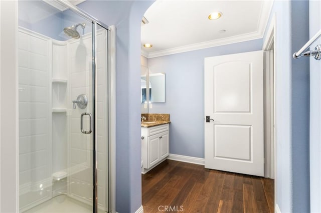 bathroom with wood-type flooring, vanity, walk in shower, and crown molding