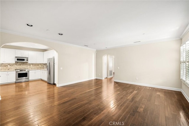 unfurnished living room featuring hardwood / wood-style flooring and ornamental molding